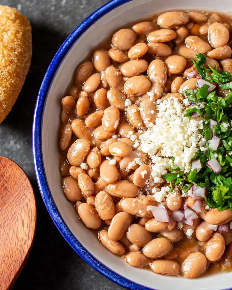 Bowl of cooked pinto beans ready to serve with herbs and spices.