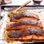 Maple Chili Broiled Salmon garnished with herbs on a plate
