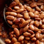Bowl of cooked pinto beans ready for a healthy meal.