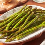 Plate of perfectly roasted asparagus garnished with herbs