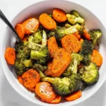 Oven-roasted broccoli and carrots served on a plate, showcasing vibrant colors.