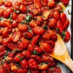 Bowl of roasted cherry tomatoes drizzled with olive oil and herbs