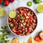 Freshly prepared strawberry salsa with diced strawberries and herbs