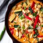 Bowl of Thai chicken coconut curry with vibrant vegetables and herbs