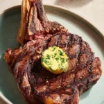 Cooked Tomahawk Steak on a wooden cutting board garnished with herbs