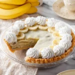 Delicious vegan banana cream pie topped with whipped coconut cream and banana slices.