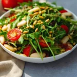 A delicious arugula salad topped with cherry tomatoes and feta cheese.