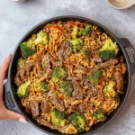 A bowl of Beef Lo Mein topped with sliced beef and colorful vegetables.