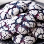 Freshly baked blueberry crinkle cookies on a rustic wooden table