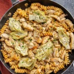 Chicken Artichoke Pasta dish with creamy sauce and garnished herbs