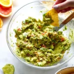 Bowl of Chunky Citrus Guacamole garnished with lime and cilantro