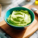 Bowl of creamy avocado dip with fresh ingredients and tortilla chips