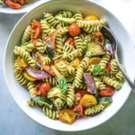 Creamy avocado pasta salad with roasted vegetables in a bowl