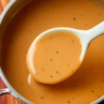 Bowl of easy homemade chicken gravy ready to serve over chicken and potatoes