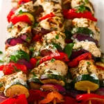 Plate of Greek chicken kebabs served with tzatziki sauce
