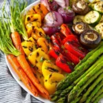 A colorful assortment of grilled vegetables including bell peppers, zucchini, and eggplant.