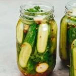 Jars of homemade pickles with fresh vegetables and spices