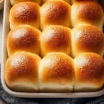 Freshly baked homemade soft dinner rolls on a wooden table