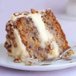 Delicious Hummingbird Cake topped with cream cheese frosting and pecans