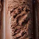 Bowl of malted chocolate ice cream topped with chocolate shavings and nuts