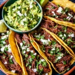 Delicious Mexican shredded beef tacos topped with fresh ingredients