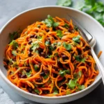 Colorful Moroccan Carrot Salad with spices and herbs in a bowl.