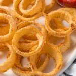 Golden brown oven baked onion rings on a plate