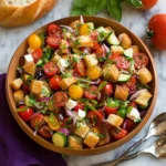A vibrant Panzanella Salad with tomatoes, bread, and basil herbs in a bowl.