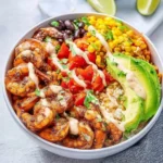 Fresh shrimp burrito bowl topped with vibrant vegetables and sauces
