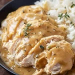 Slow cooker chicken and gravy served in a bowl with mashed potatoes