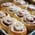 Homemade Cinnabon cinnamon rolls drizzled with cream cheese frosting