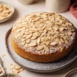 Delicious vegan almond cake garnished with almond slices and berries