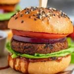 Delicious vegan black bean burgers on a wooden table with fresh ingredients.