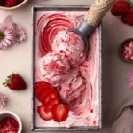 Bowl of homemade Vegan Strawberry Ice Cream topped with fresh strawberries.