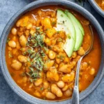 Bowl of creamy white bean chili topped with fresh herbs
