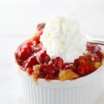 Delicious cherry dump cake served warm with a scoop of vanilla ice cream.