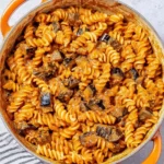 Creamy eggplant pasta dish served in a bowl with fresh herbs and cheese