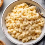 Creamy crockpot mac and cheese served in a bowl with cheese melting