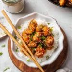 Delicious plate of Hoisin Chicken garnished with green onions and served with rice
