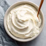 Homemade sour cream in a bowl garnished with herbs.