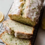 Slice of moist Lemon Zucchini Bread topped with lemon zest and served on a plate.