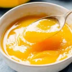 Delicious mango sauce in a bowl with fresh mangos