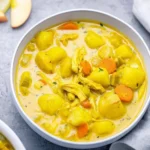 A bowl of Mulligatawny Soup with spices and vegetables, showcasing its rich color and texture.