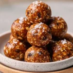 No bake almond butter oatmeal balls stacked on a plate.