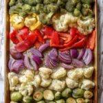 A colorful plate of oven roasted vegetables including carrots, bell peppers, and zucchini.