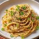 Delicious sesame noodles garnished with scallions and sesame seeds