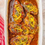 Baked Mississippi Chicken served on a white plate with herbs