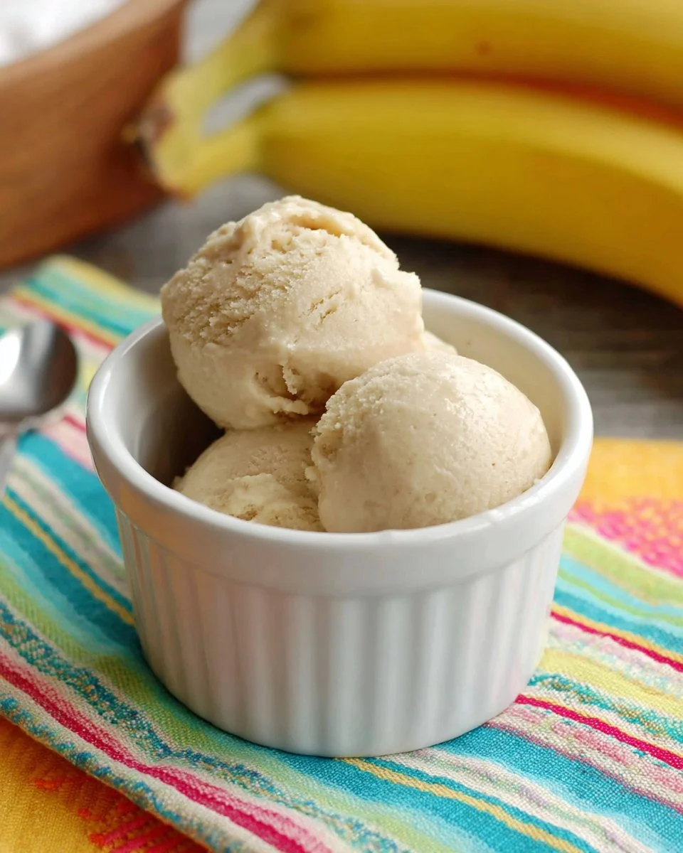 Delicious bowl of homemade banana ice cream topped with slices of fresh banana.