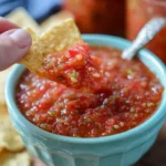 Jar of best homemade canned salsa with fresh ingredients on a wooden table