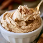 A jar of homemade Cinnamon Maple Butter with a spoon, ideal for toast and pancakes.